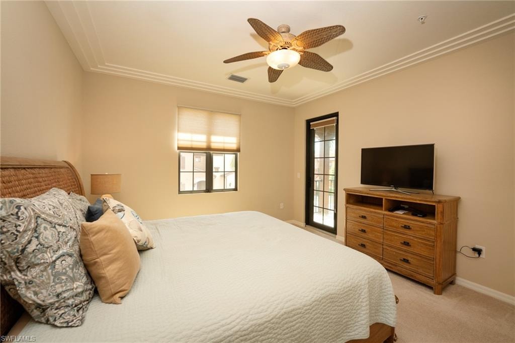 Carpeted bedroom featuring ceiling fan and ornamental molding