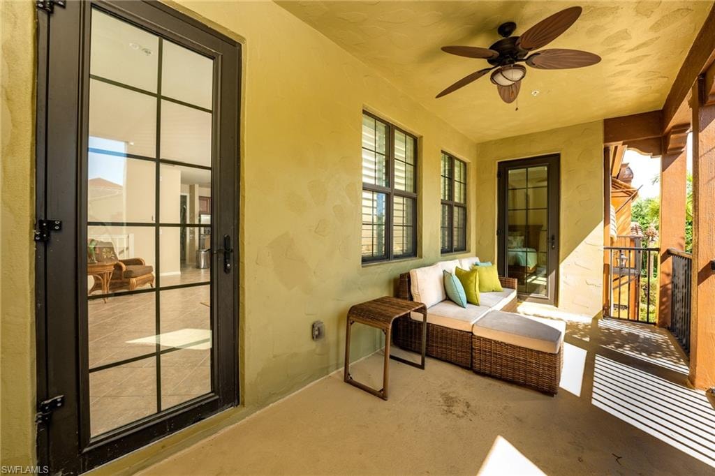 Sunroom featuring healthy amount of natural light, a ceiling fan, and an outdoor hangout area
