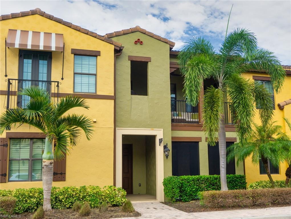View of front of property with a balcony, stucco siding, and a tile roof