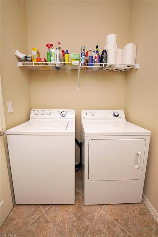Washroom with washing machine and dryer and baseboards
