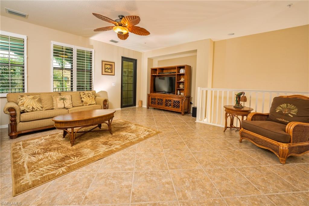 Living area with ceiling fan and light tile patterned flooring