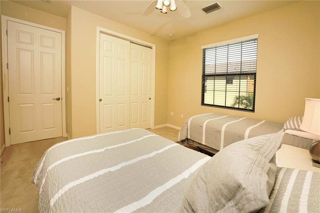 Bedroom with carpet flooring, a closet, and a ceiling fan