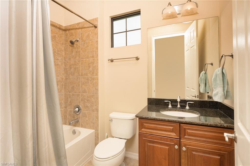 Bathroom featuring shower / bath combination with curtain and vanity