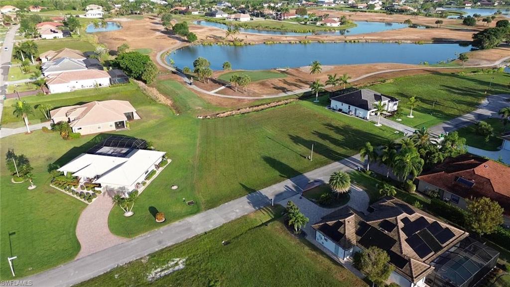 Aerial view of property and surrounding area featuring a large body of water and nearby suburban area