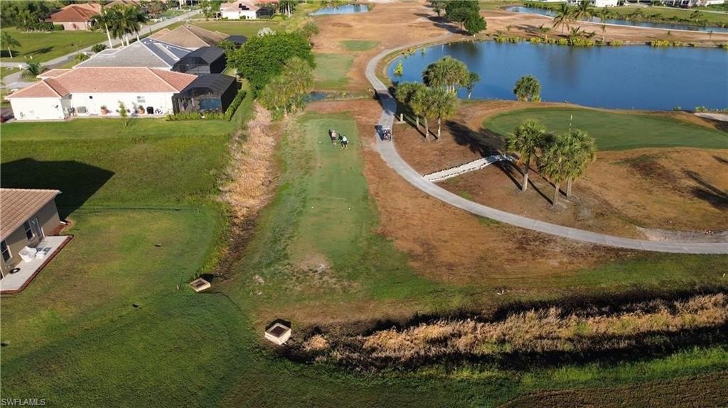 Aerial view of property and surrounding area featuring a nearby body of water, a golf club, and nearby suburban area