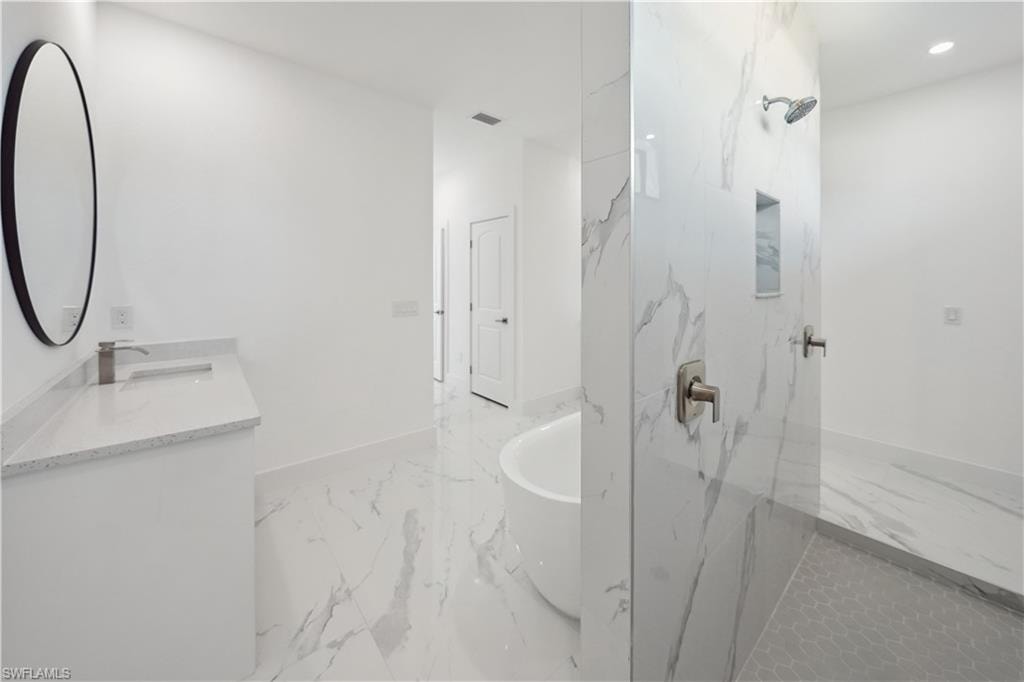 Bathroom featuring a soaking tub, light marble finish flooring, vanity, a marble finish shower, and recessed lighting