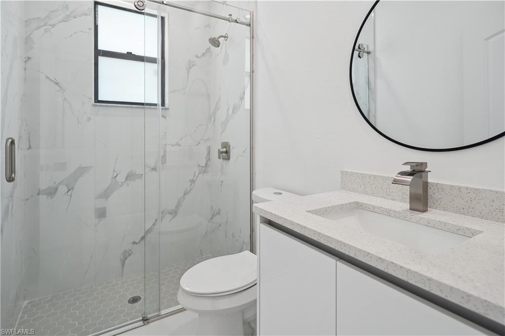 Bathroom with vanity and a marble finish shower