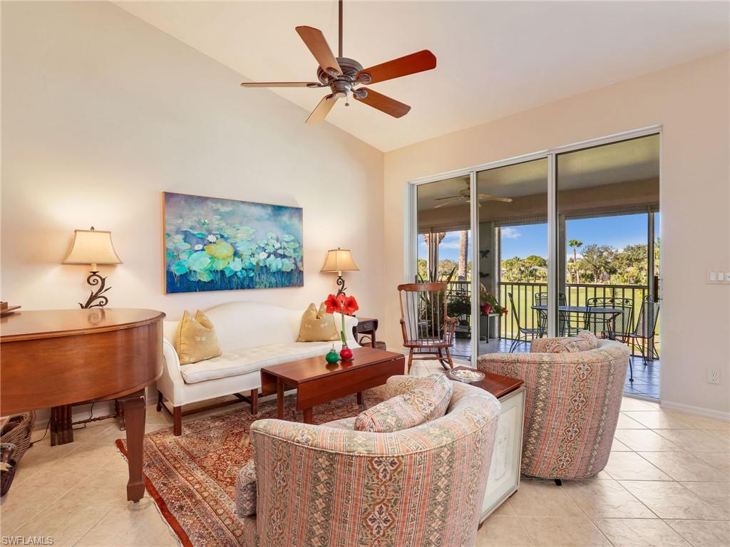 Living area featuring lofted ceiling, a ceiling fan, and light tile patterned flooring