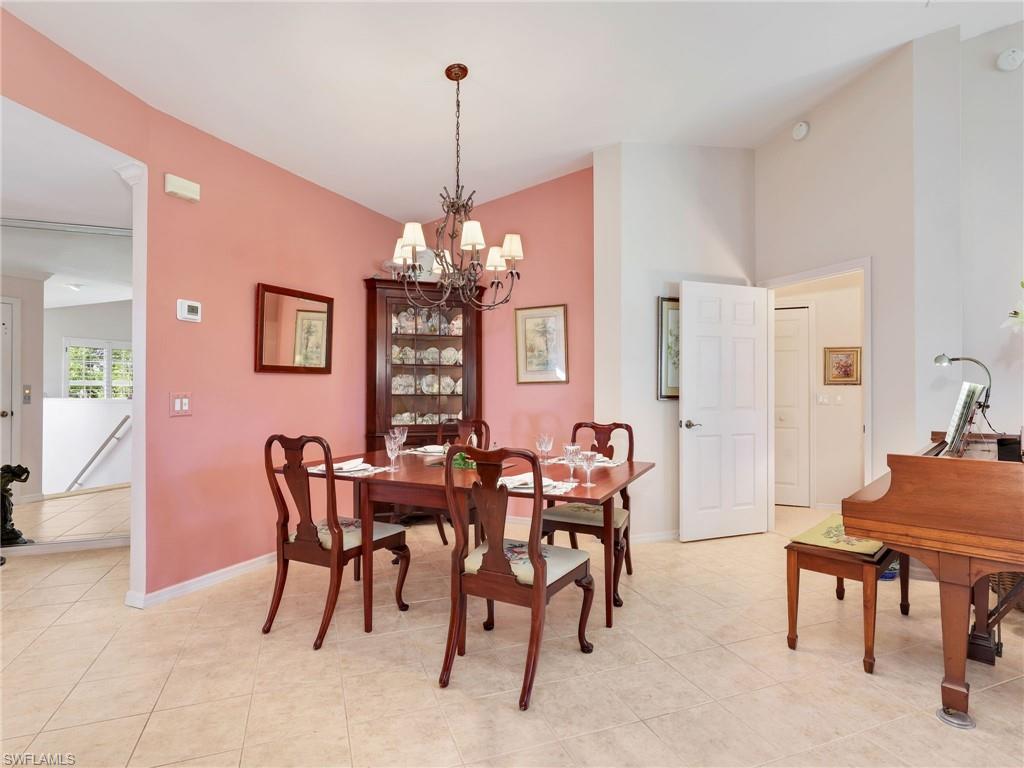 Dining area with a chandelier, vaulted ceiling, and light tile patterned floors