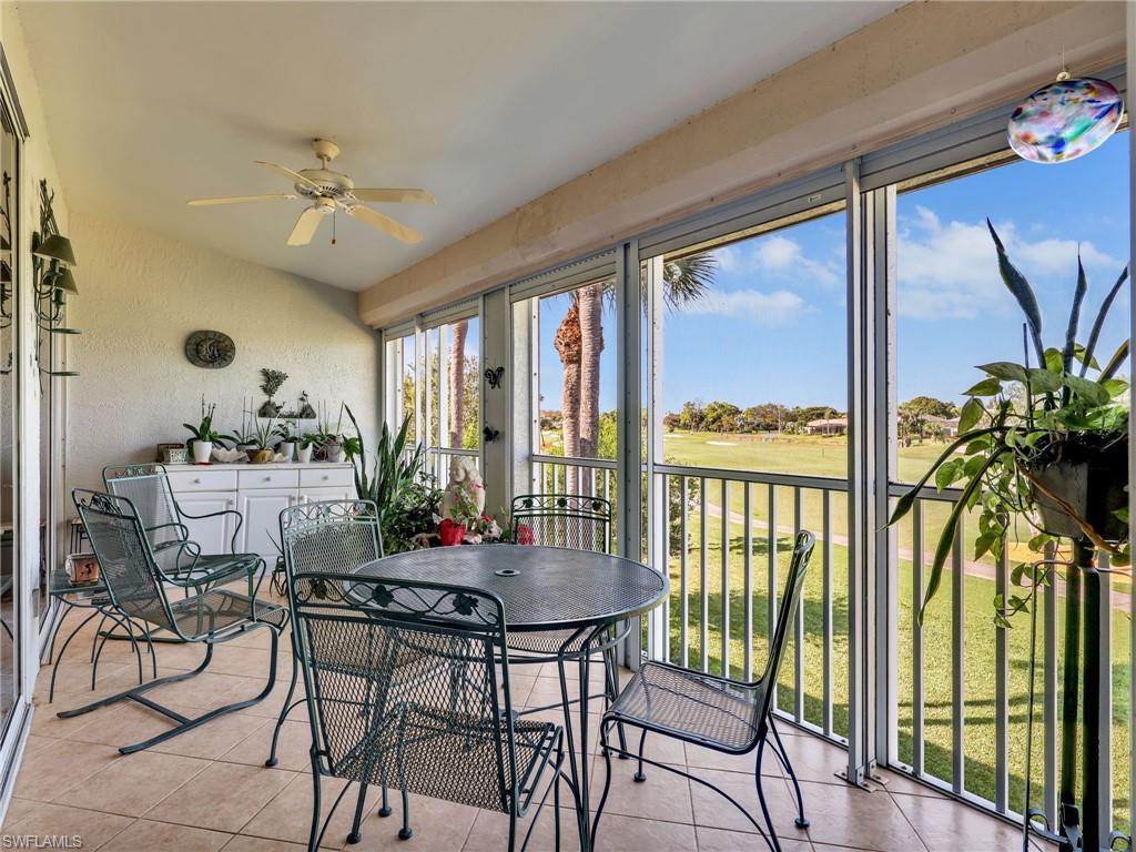 Lanai featuring electric storm shutters, golf course and water views view, and tile patterned floors