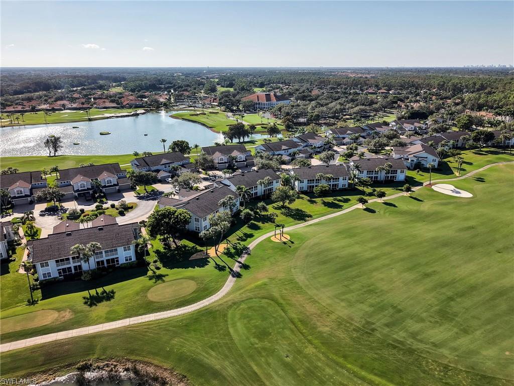 Aerial perspective of suburban area featuring a golf course and a large body of water