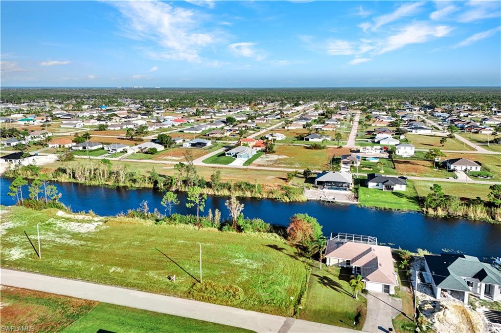 Aerial perspective of suburban area featuring a nearby body of water