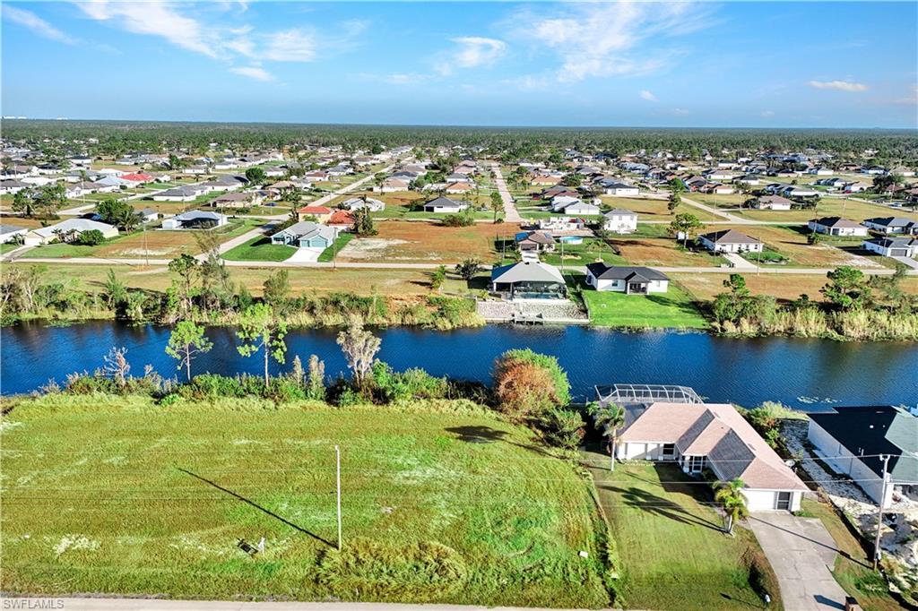 Aerial perspective of suburban area featuring a nearby body of water