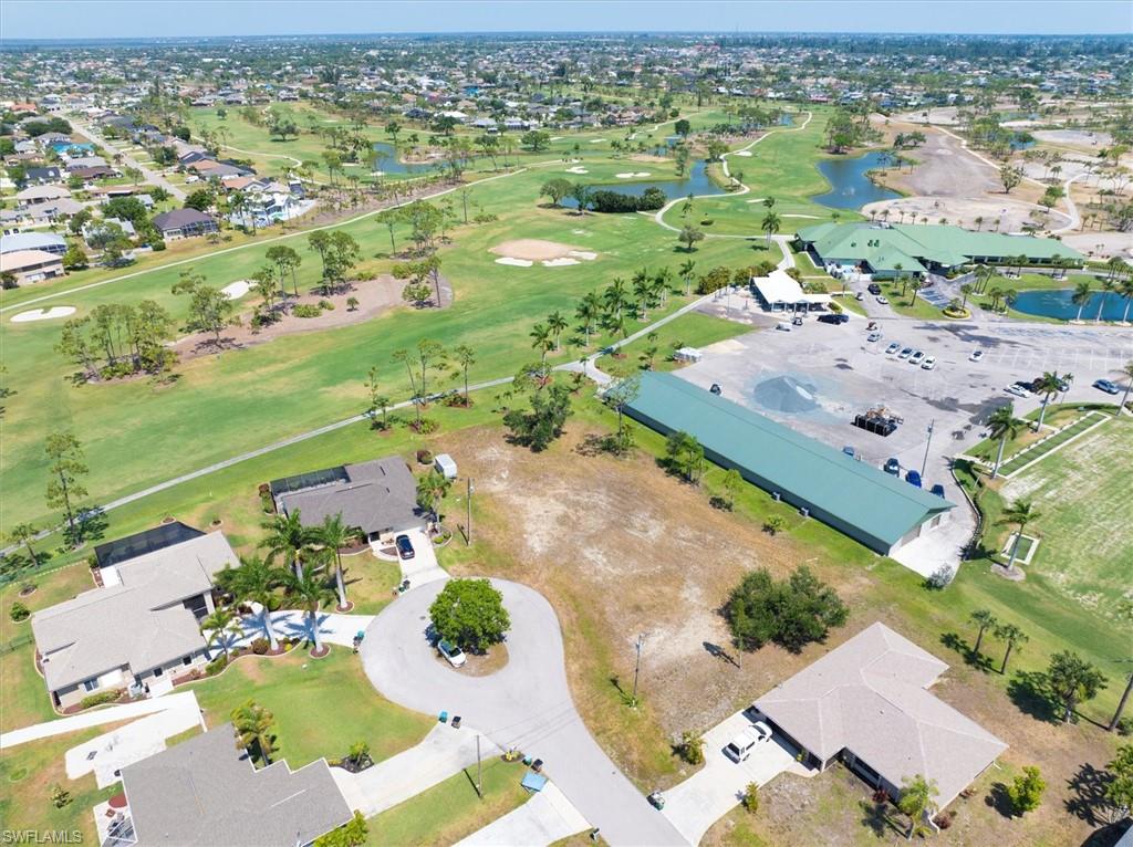 Aerial view of property's location featuring nearby suburban area, a golf course, and a large body of water