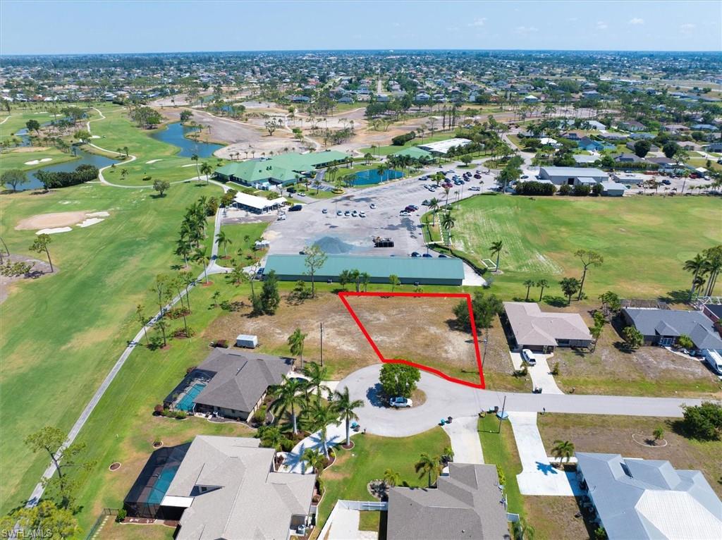 View of property location featuring a golf club, nearby suburban area, and property parcel outlined