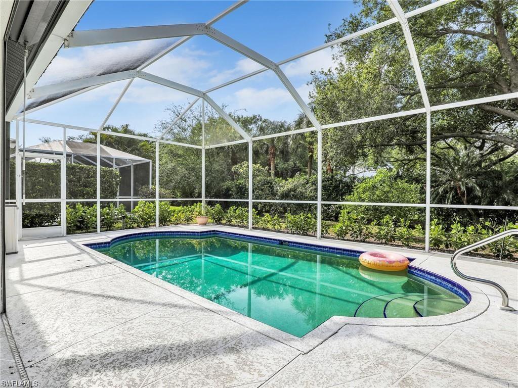 Swimming pool featuring glass enclosure, a sunroom, and a patio