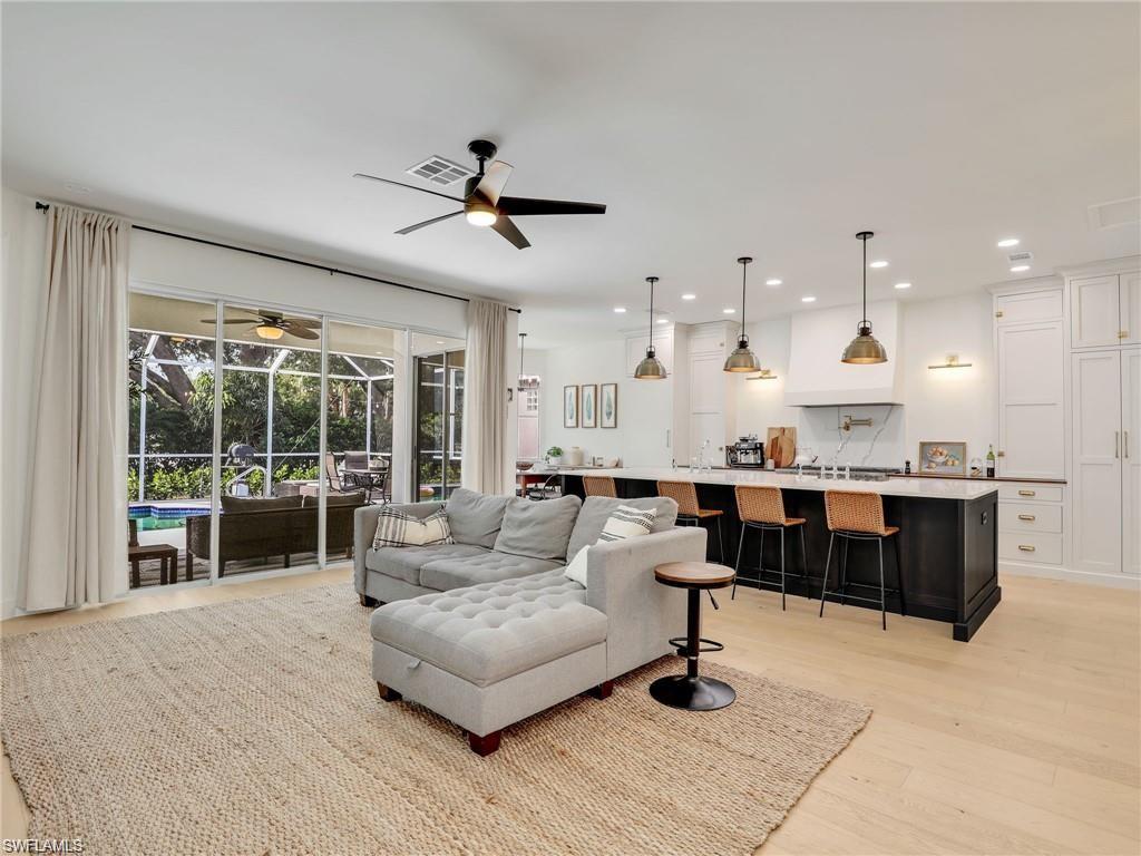 Living area featuring light wood-style floors, a sunroom, a ceiling fan, and recessed lighting