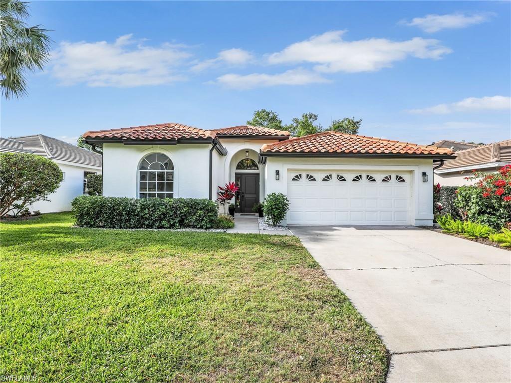 Mediterranean / spanish-style home with stucco siding, concrete driveway, a front yard, a tile roof, and an attached garage