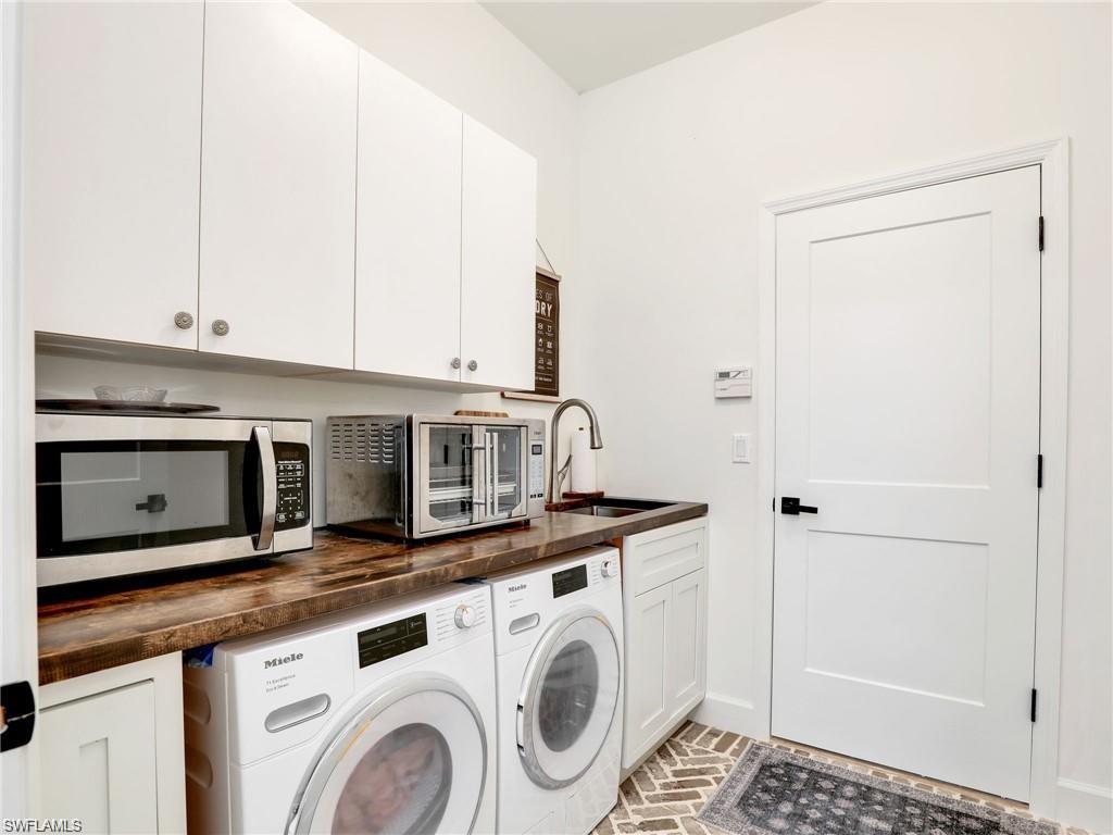 Laundry area with brick floors and washing machine and dryer