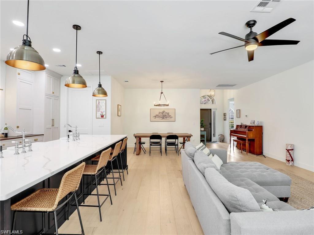 Living area with light wood finished floors, a ceiling fan, and recessed lighting