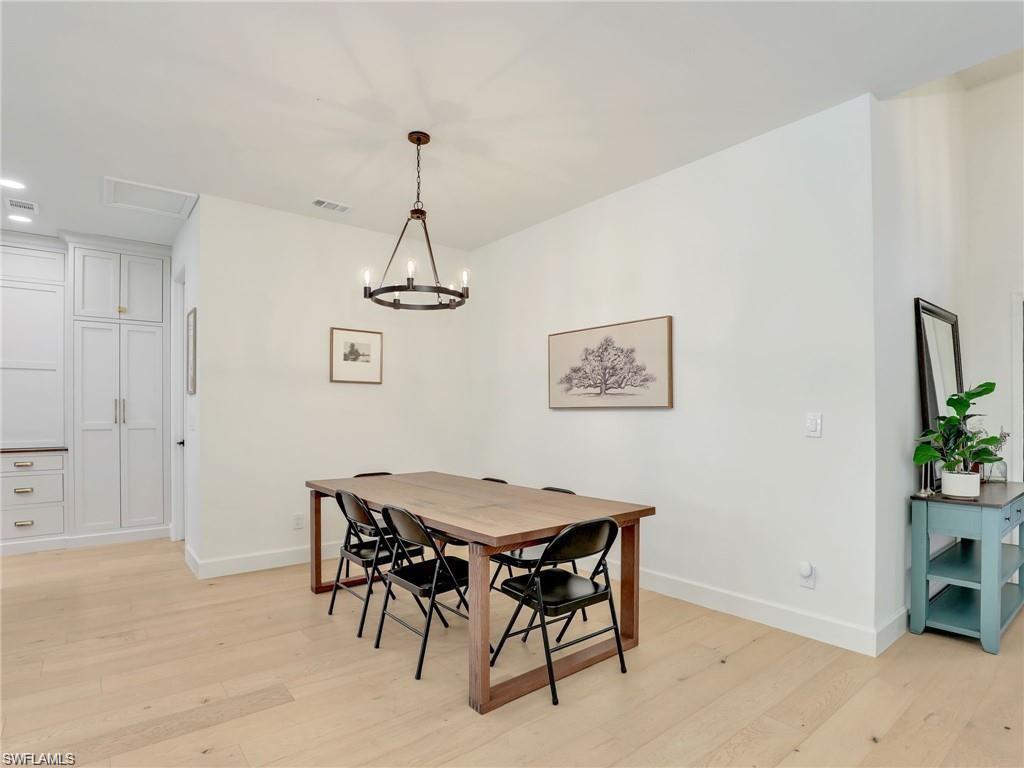 Dining space with light wood-style flooring, a chandelier, and recessed lighting