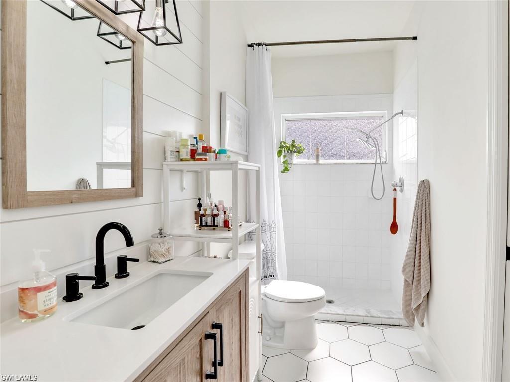 Full bath featuring a shower stall, vanity, and light tile patterned floors