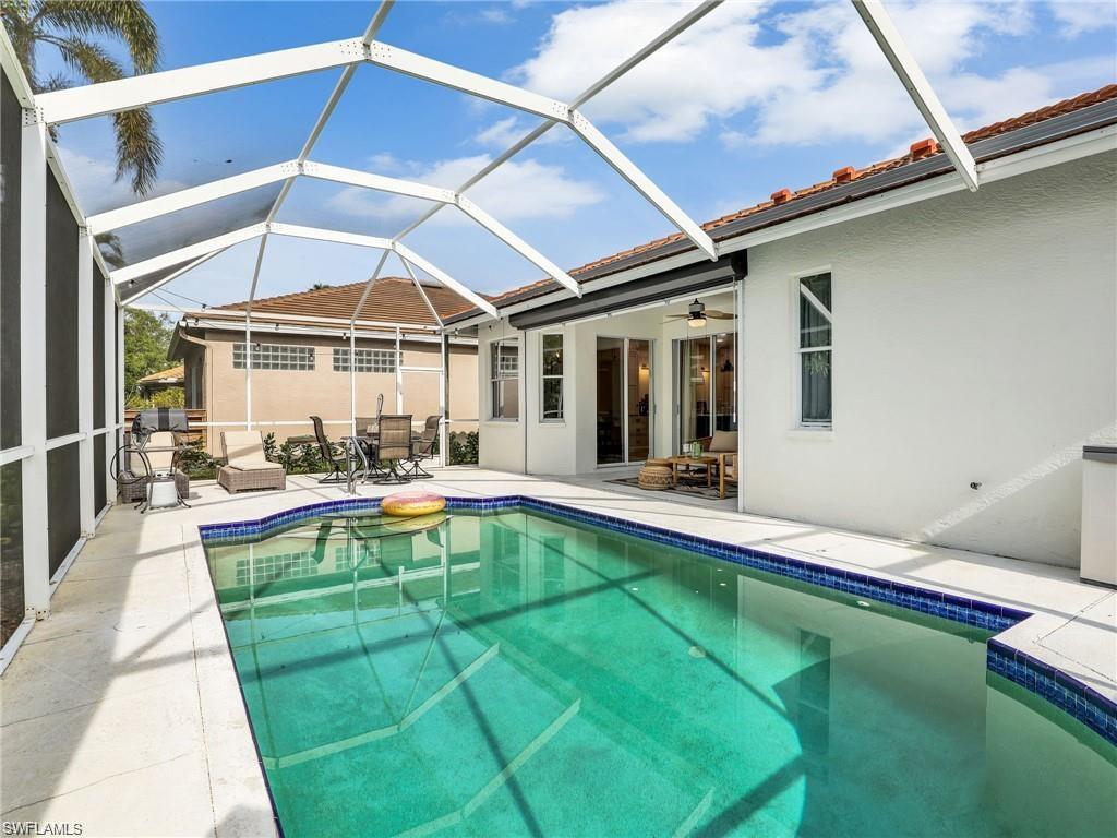 Swimming pool with a patio area, a sunroom, glass enclosure, and outdoor dining space