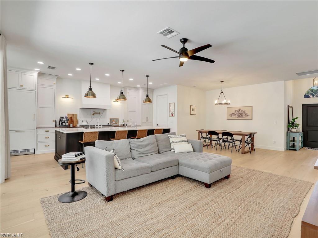 Living room with a ceiling fan, light wood-type flooring, and recessed lighting