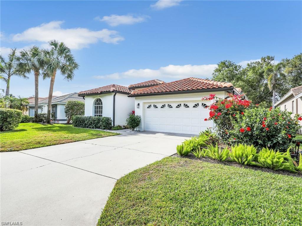 Mediterranean / spanish home featuring a front yard, stucco siding, driveway, an attached garage, and a tiled roof