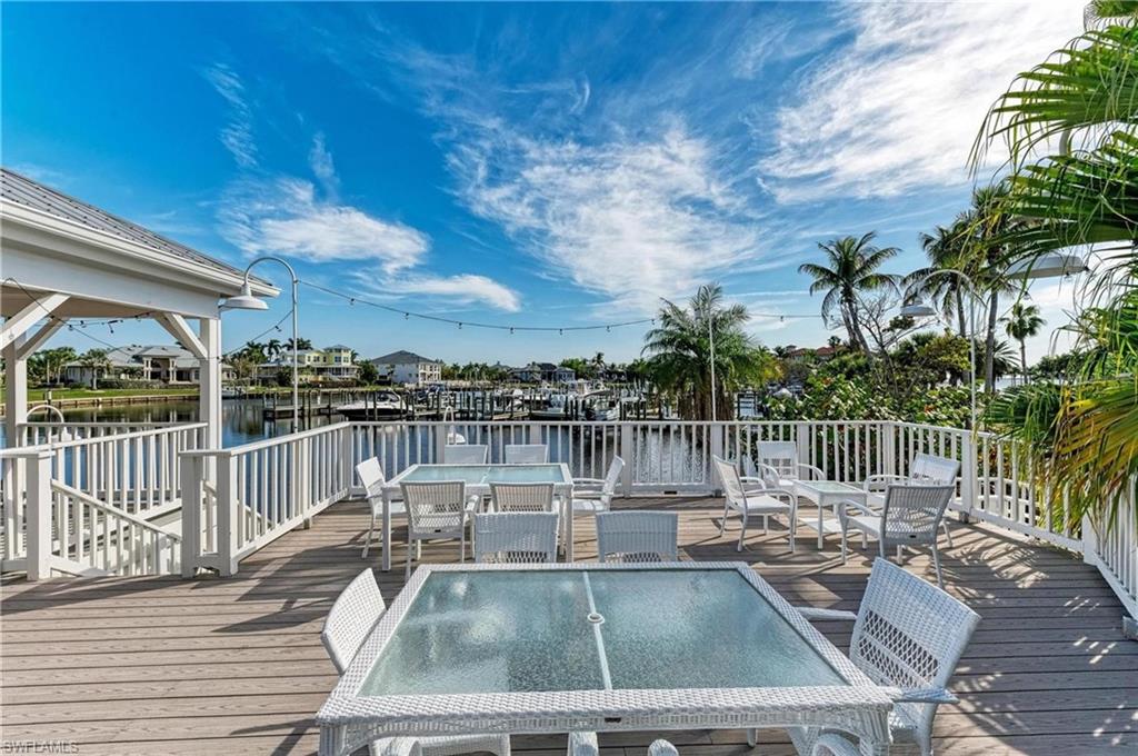 Wooden terrace featuring outdoor dining area and a water view