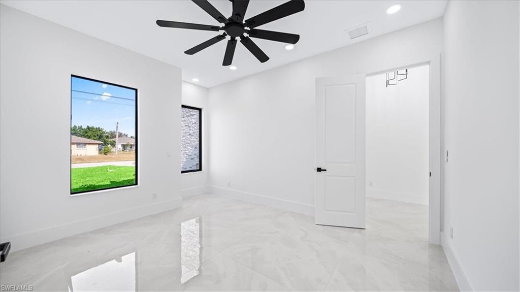 Spare room featuring recessed lighting, light marble finish floors, and a ceiling fan