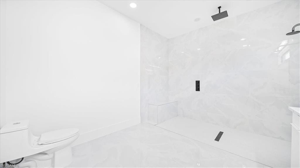Full bath featuring a marble finish shower, marble look tile flooring, and recessed lighting