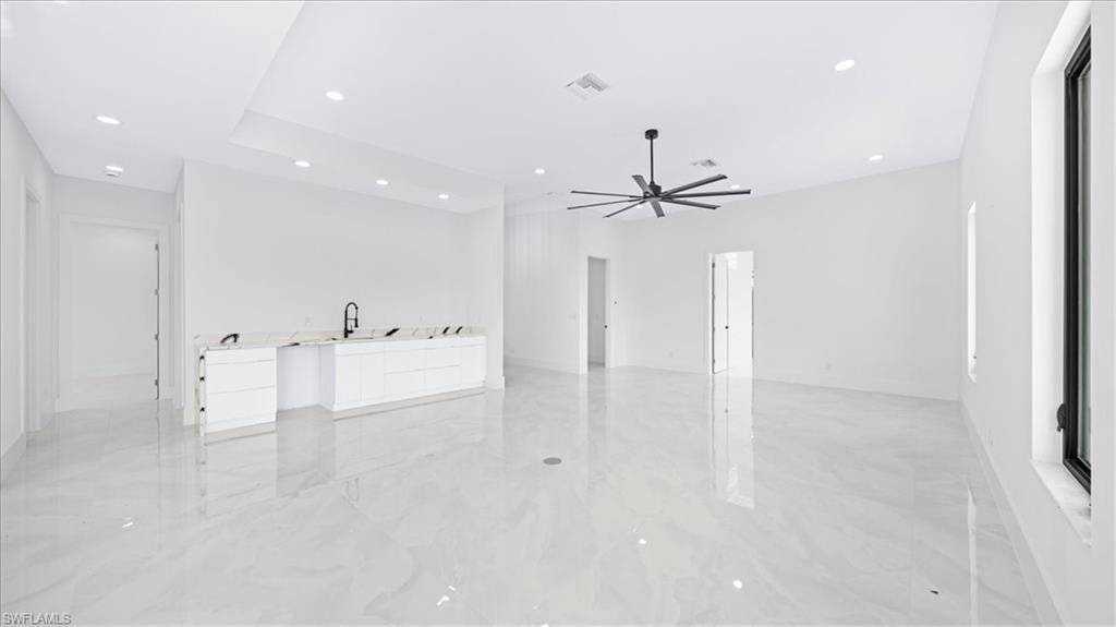 Unfurnished living room featuring light marble finish floors, recessed lighting, and ceiling fan