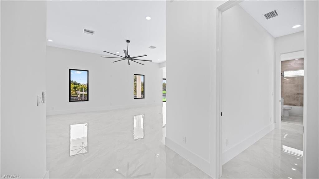 Unfurnished room featuring light marble finish flooring and recessed lighting
