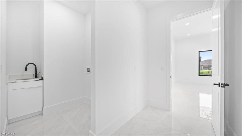 Bathroom featuring vanity, light marble finish flooring, and recessed lighting
