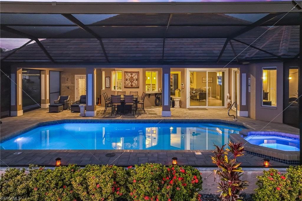 View of pool featuring a patio area, a lanai, outdoor dining space, and a sunroom