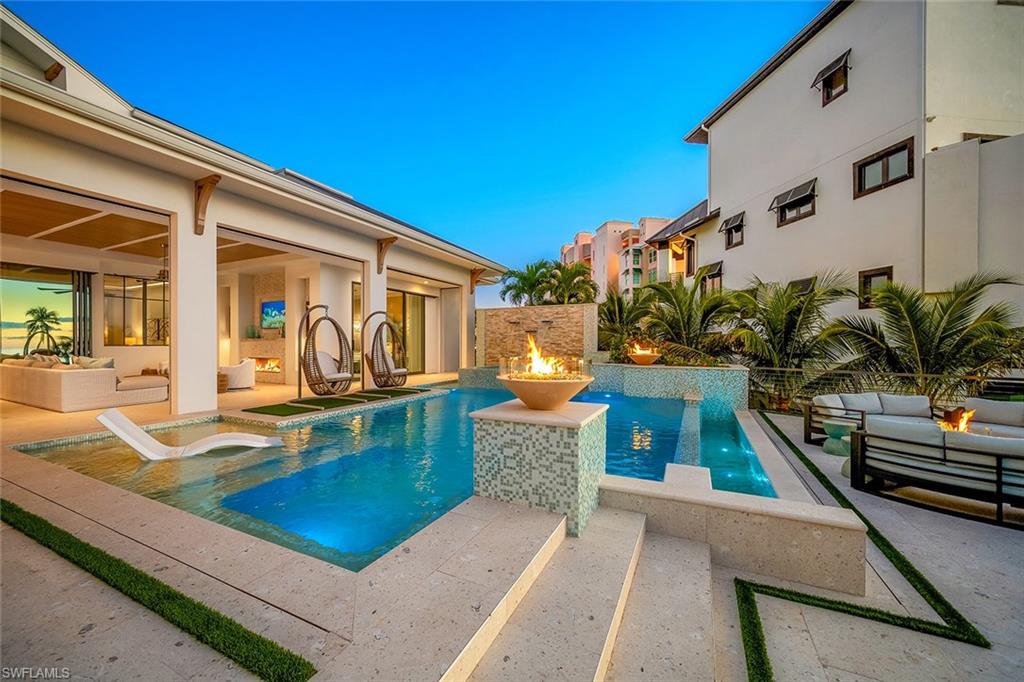Swimming pool with an outdoor living space with a fire pit, a patio area, and a hot tub