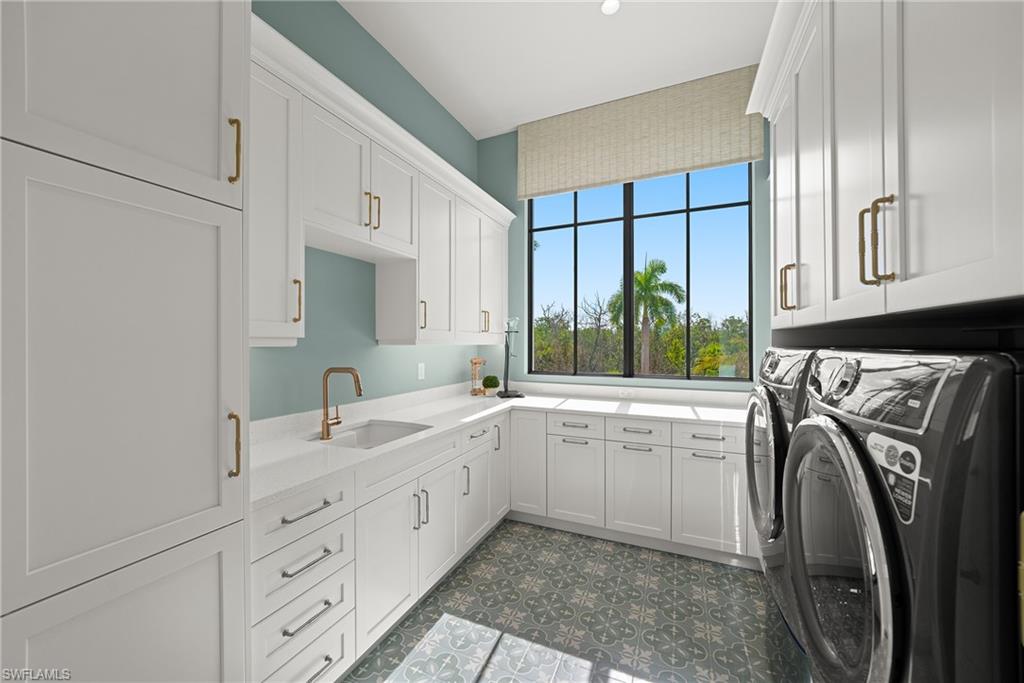 Washroom with cabinet space, washing machine and clothes dryer, and dark floors