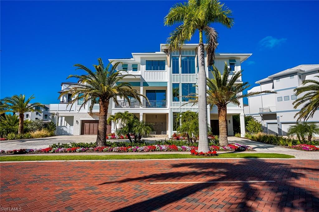 View of front of property with decorative driveway, stucco siding, and a balcony