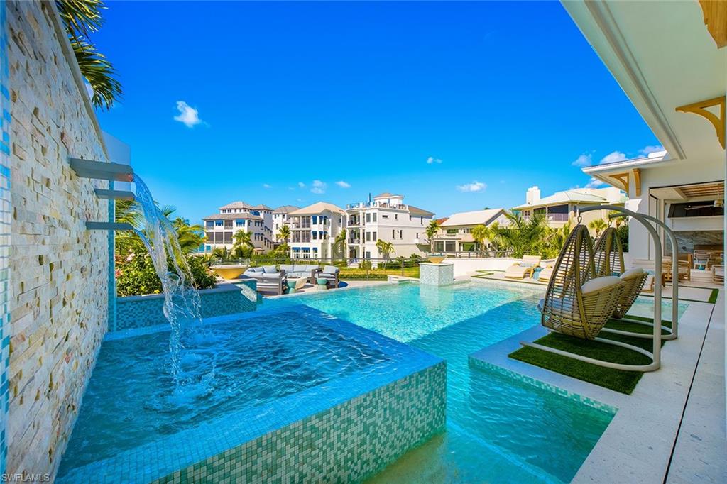 View of pool featuring a patio area, a pool with connected hot tub, an outdoor hangout area, and a residential view