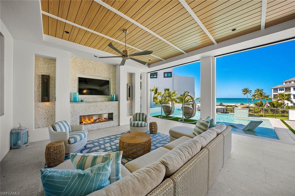 View of patio / terrace with ceiling fan, an outdoor living space with a fireplace, and an outdoor pool