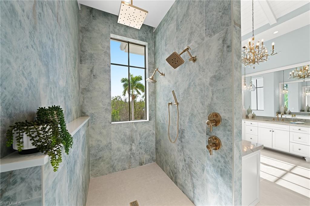 Bathroom with walk in shower, vanity, a chandelier, and light tile patterned floors