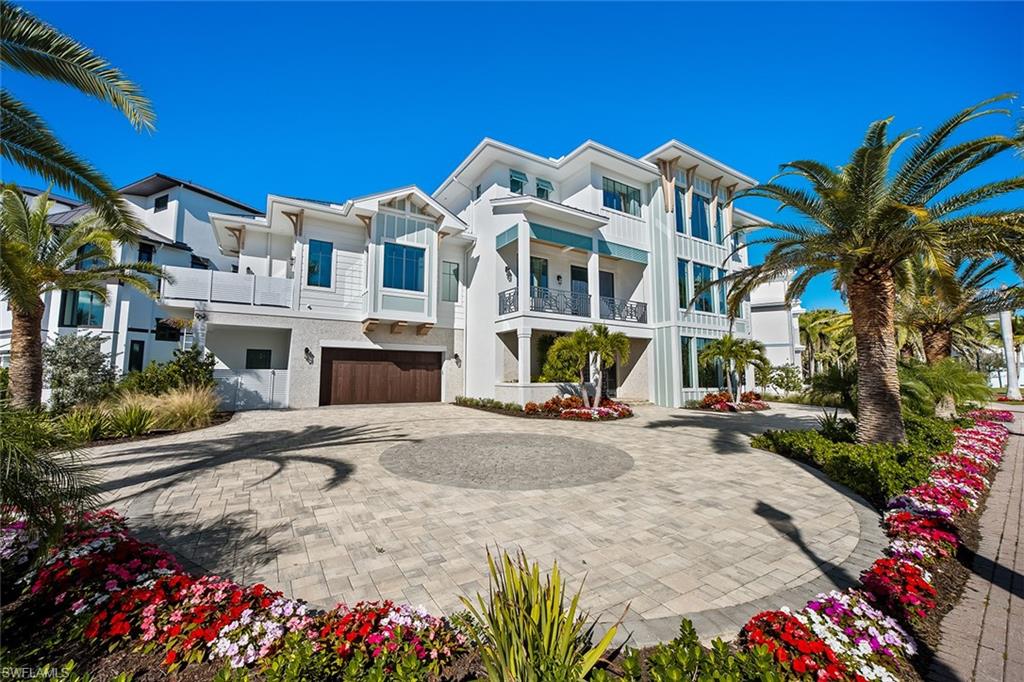 View of front of home featuring stucco siding, decorative driveway, a balcony, and a garage