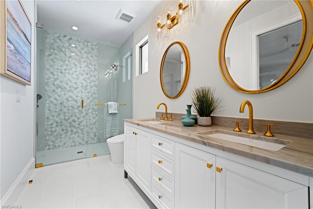 Full bath featuring light tile patterned floors, double vanity, a stall shower, and recessed lighting