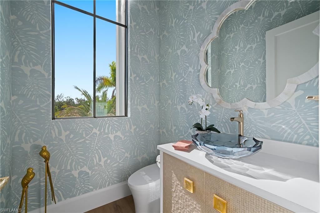 Bathroom featuring wallpapered walls and vanity