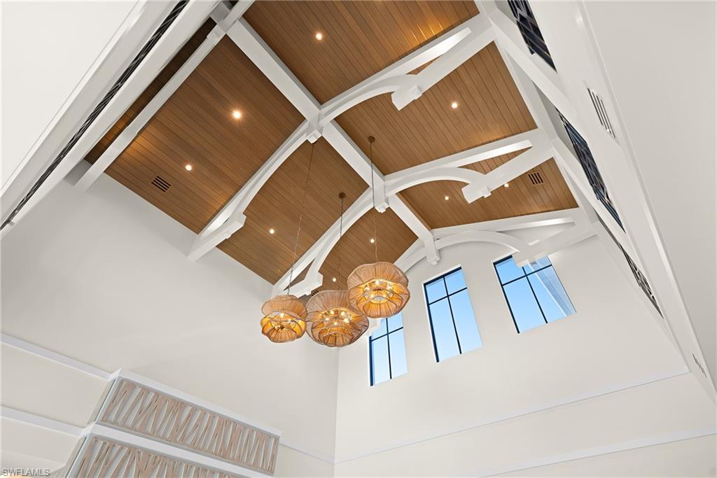 Detailed view of a chandelier, a skylight, and a wooden ceiling with exposed beams