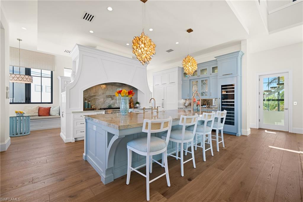 Kitchen featuring plenty of natural light, a kitchen bar, decorative light fixtures, a large island, and recessed lighting