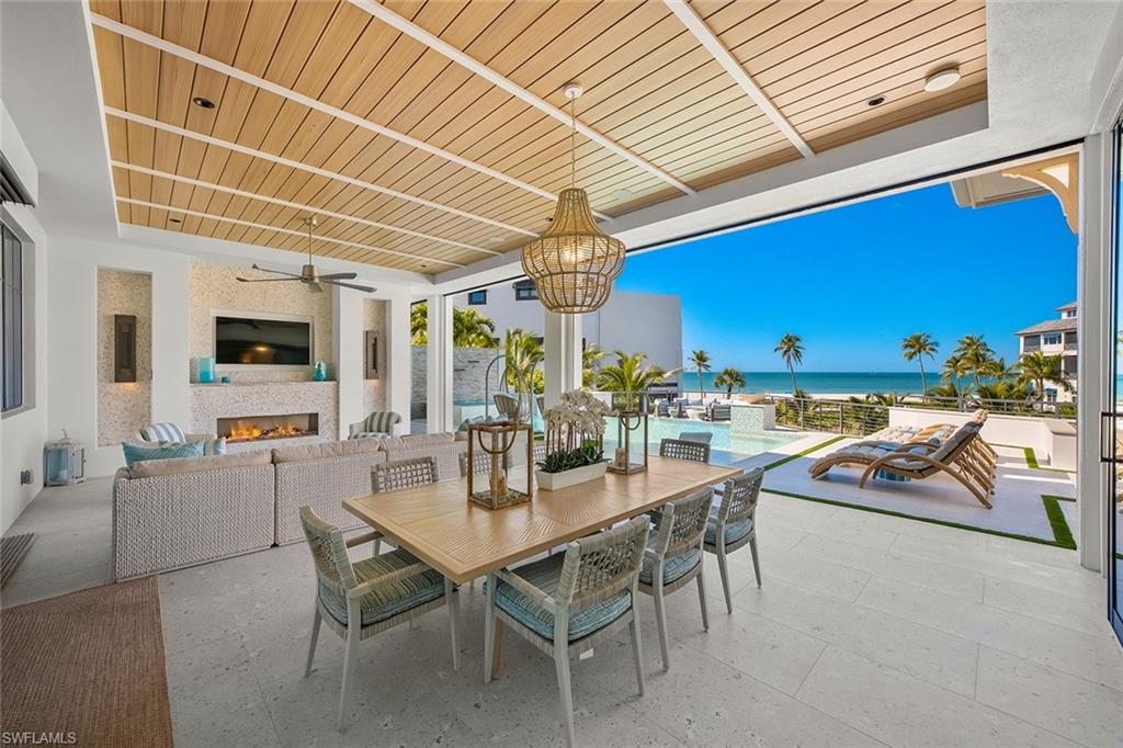 View of patio / terrace featuring an outdoor living space with a fireplace, a ceiling fan, outdoor dining space, and an outdoor pool