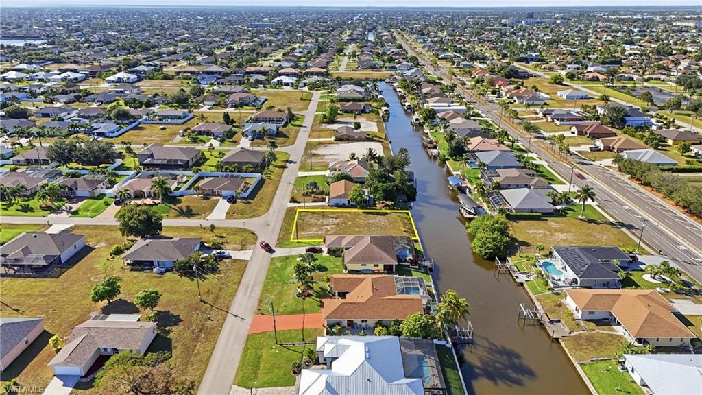 Aerial view of property and surrounding area featuring nearby suburban area and property boundaries highlighted
