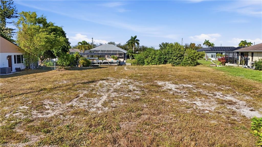View of grassy yard featuring a sunroom and a lanai